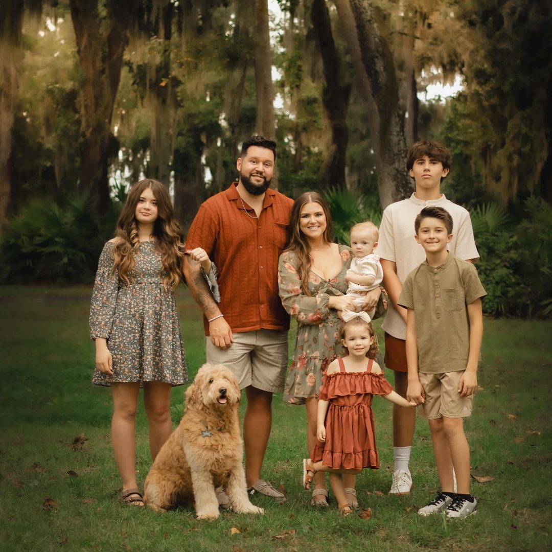 The Patrick family photographed together outdoors beneath live oaks in Northeast Florida